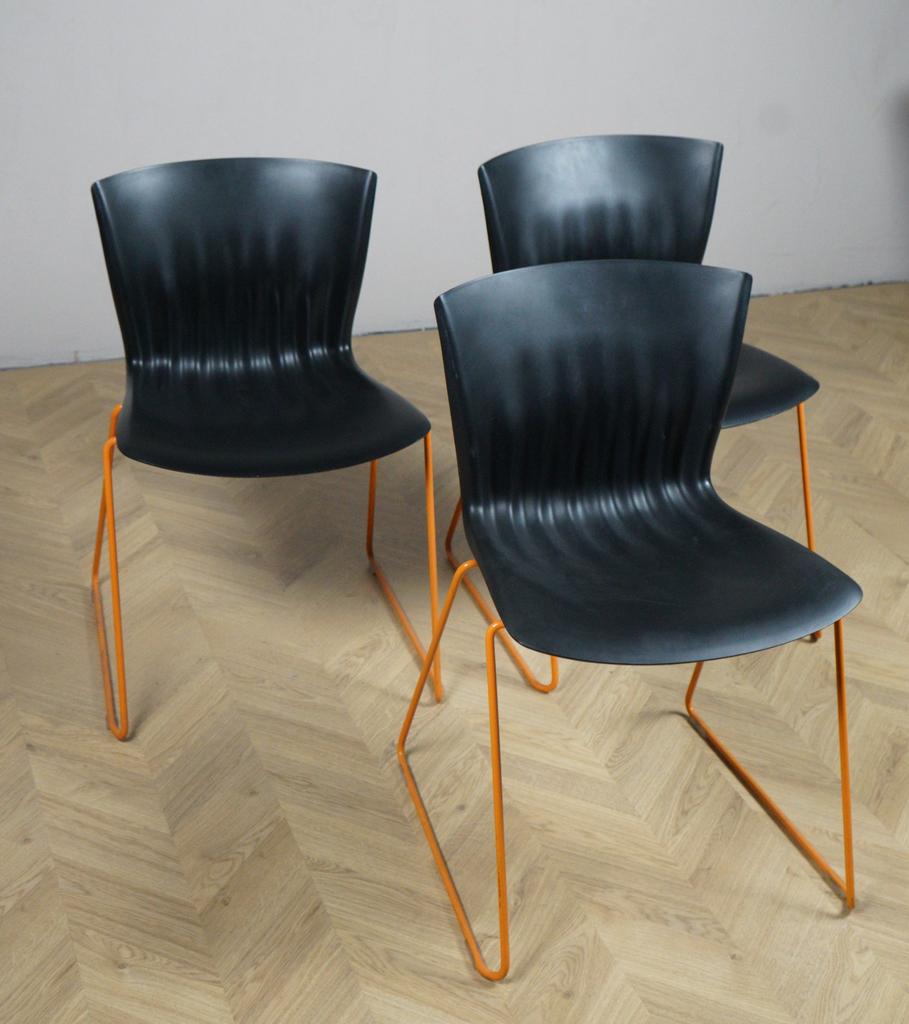 Skrå visning af Paustian Ripple spisebordsstol i sort og orange med moderne design – perfekt som spisebordsstol og mødestol.